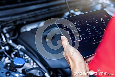 Car service mechanic using digital tablet with diagnostics software to check engine condition. vehicle inspection Stock Photo