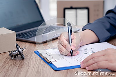 Car service staff write on the white paper clip file board part list and stock check with car thermostat of engine car Stock Photo