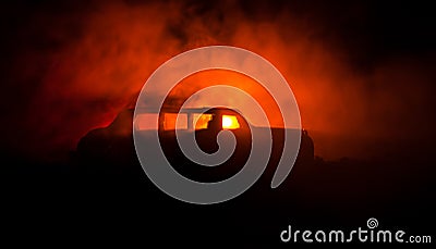 The car in the shadows with glowing lights in low light, or silhouette of limousine car dark background. Stock Photo