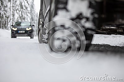 Car on a snowy winter road amid forests Stock Photo