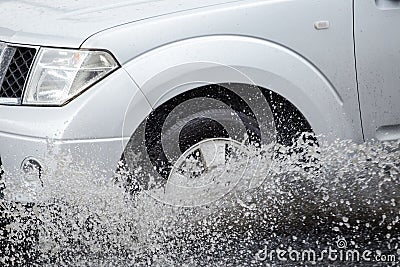 Car splashes through a large puddle on a flooded street Stock Photo