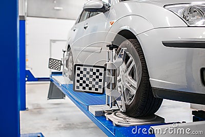 Car on stand with sensors wheels for alignment camber check in workshop of Service station. Stock Photo