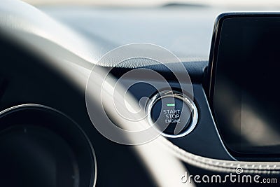 Car Start-Stop Engine Button of a modern car in the interior of the expensive car. Black leather car interior with white stitching Stock Photo