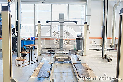 A Car on the Car Steering Wheel Balancer and Calibrate with laser reflector attach on each tire to center driving adjust in the Stock Photo