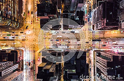 Car, taxi, and bus traffic on road intersection at night in Hong Kong downtown district, drone aerial top view. Asia city life Stock Photo