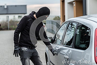 Car thief pulls the handle of a car. Stock Photo