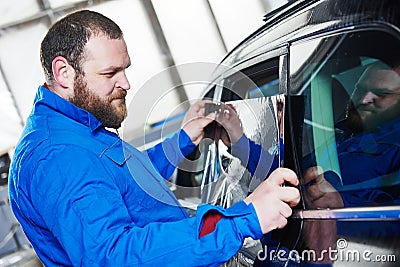 Car tinting. Automobile mechanic technician applying foil Stock Photo