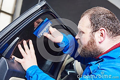 Car tinting. Automobile mechanic technician applying foil Stock Photo