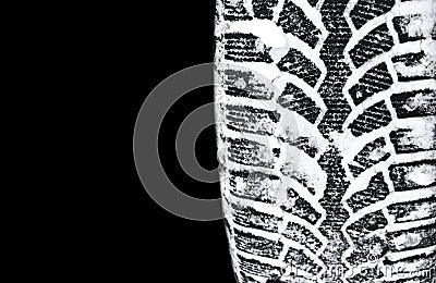 The car tire in the snow close up. Car tracks on the snow. Traces of the car in the snow. Winter tires. Tyres covered with snow at Stock Photo