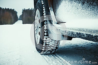 Car tires covered with snow on winter road. Stock Photo