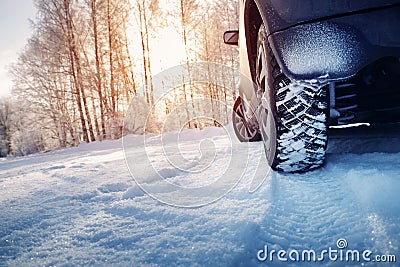 Car tires on winter road covered with snow Stock Photo