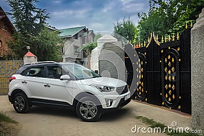 A car about to enter a house through the gate which is closed at the moment. Editorial Stock Photo