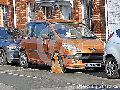 Car vehicle clamped wheel clamp illegal road park parking cars autos tax police notice Editorial Stock Photo