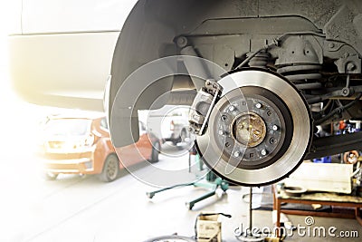 Car service - mechanic unscrewing brake disc of the vehicle for repair Stock Photo