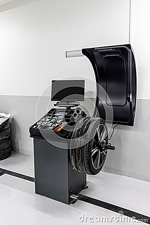 Car wheel balancing service. Car wheel balancing in tire service. Mechanic working with wheel balancing machine at tire service, Stock Photo