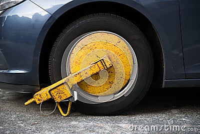 Car wheel blocked by wheel lock because illegal parking violation Stock Photo