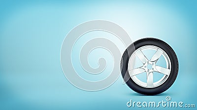 A car wheel with five spokes standing on the tire rim on blue background. Stock Photo
