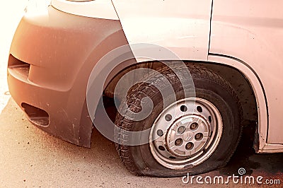 Car wheel flat tire on the road. Small white truck with punctured wheel Stock Photo