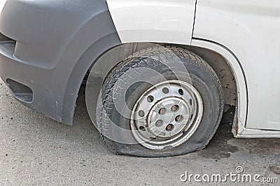 Car wheel flat tire on the road. Small white truck with punctured wheel Stock Photo