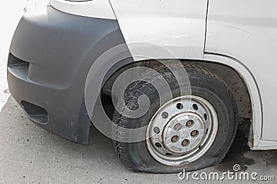 Car wheel flat tire on the road. Small white truck with punctured wheel Stock Photo