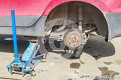 Car without wheel lift up by hydraulic, waiting for tire replacement Stock Photo