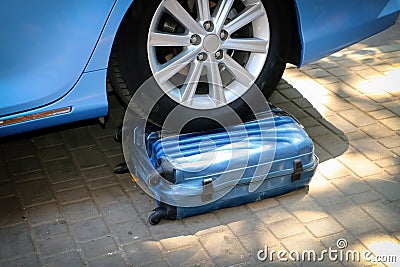 Car wheel on a suitcase, the car ran into a suitcase. Stock Photo