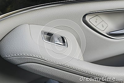 Car white leather interior details of door handle with windows controls and adjustments. Car window controls of modern car Stock Photo