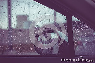 Car window with rain drops on glass or the windshield,Blurred traffic on rainy day in the city Stock Photo