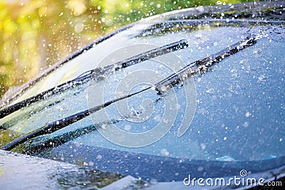 Car windshield with rain drops and frameless wiper blade Stock Photo