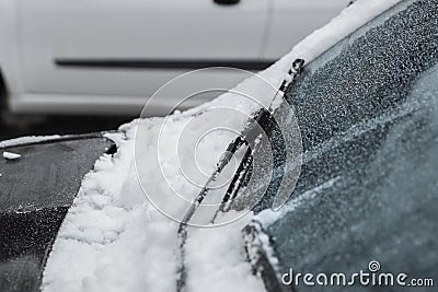 Car windshield with wiper blades cleaned from snow outdoors on winter day Stock Photo