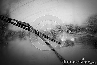 Car windshield wipers in rainy season, black and white photo with vignetting, front and rear background blurred with bokeh effect Stock Photo