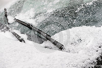 Car wiper blades clean snow from car windows. Flakes of snow covered the car with a thick layer. Safe driving Stock Photo