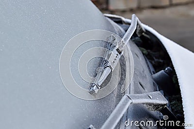 Car wiper and front window covered with frost, frosted rubber on glass. Stock Photo