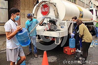 People fill containers with water from truck tanker delivery by major municipalities hydrant during COVID-19 quarantine Editorial Stock Photo