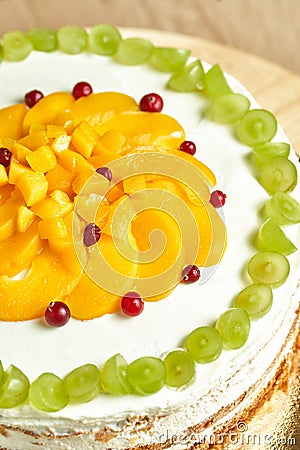 Caramel cake with fruits. Board with delicious tasty homemade cake on table. Wooden background Editorial Stock Photo