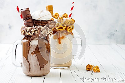 Caramel and chocolate crazy freakshake, milkshakes with brezel waffles, popcorn, marshmallow, ice cream and whipped cream. Stock Photo