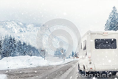 Caravan or campervan turning from road with beautiful mountain alpine landscape on background at cold winter season.Family Stock Photo