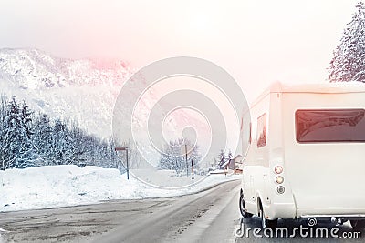 Caravan or campervan turning from road with beautiful mountain alpine landscape on background at cold winter season.Family Stock Photo