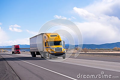 Caravan modern semi trucks on straight highway on plateau Stock Photo