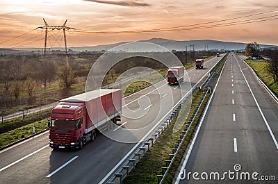 Caravan of Red Lorry trucks on highway Stock Photo