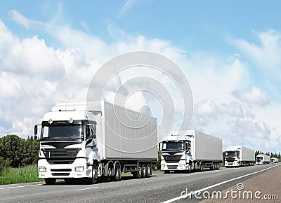 Caravan of white trucks on highway Stock Photo