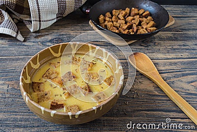 Caraway soup with croutons on rustic wooden table Stock Photo