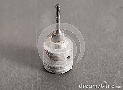 Carbide drill bit for concrete with diamond tips. Crown for socket boxes in the wall on a gray background, close-up Stock Photo