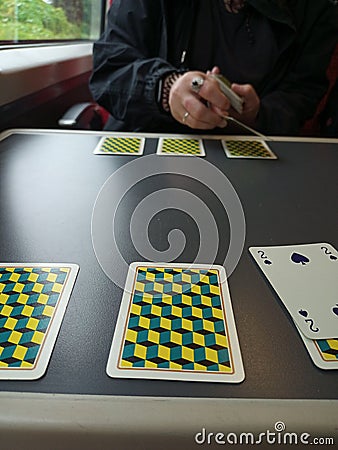 card games on a train yellow blue table person dealing Stock Photo
