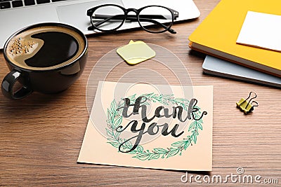 Card with phrase Thank You, laptop, glasses and notebooks on wooden table Stock Photo