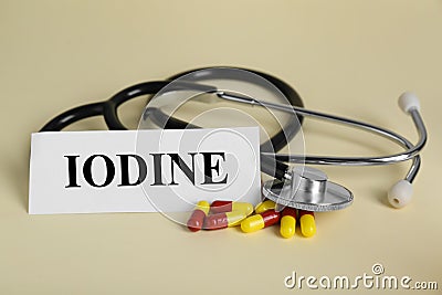 Card with word Iodine, stethoscope and pills on beige background Stock Photo