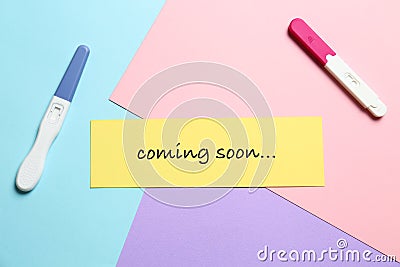 Card with words COMING SOON and pregnancy tests, flat lay Stock Photo