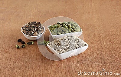 Cardamom Powder, Seeds, and Pods in Bowls Stock Photo