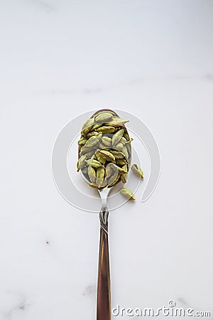 Cardamom seeds in spoon. Green and healthy spice concept. Seasoning for food and drinks Stock Photo