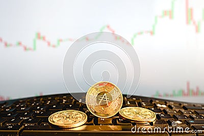 Cardano digital currency, ADA, in gold coins, on a broker`s computer keyboard Editorial Stock Photo